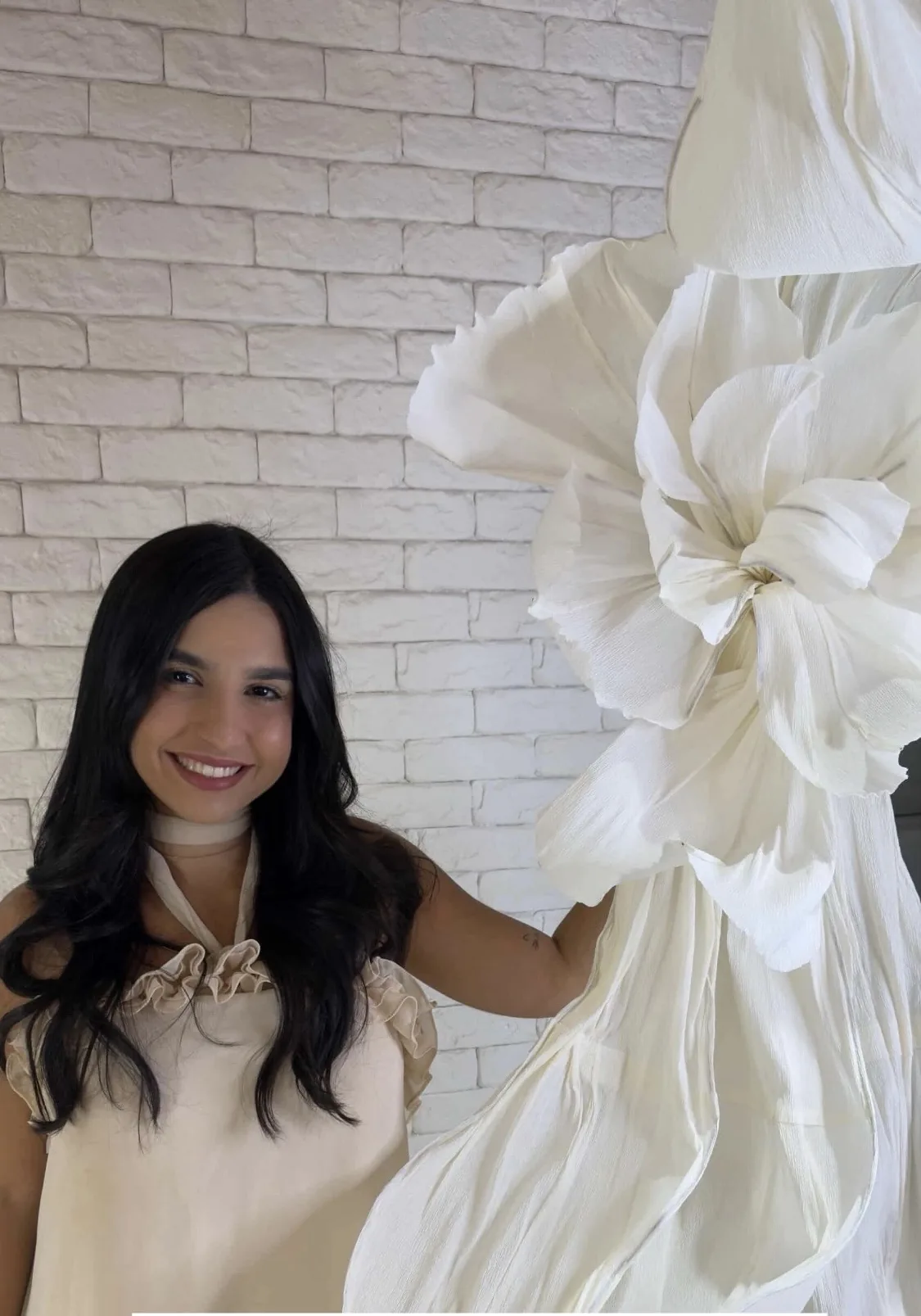 Student beside a white Oversized Flower in the studio